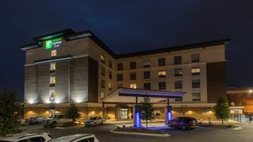 Un hôtel Holiday Inn Express doté d’une entrée abritée, de nombreux espaces de stationnement et d’une façade bien éclairée.