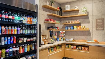 Et velassorteret område med drikkevarer og snacks, med hylder fyldt med forskellige drikke og forpakninger.