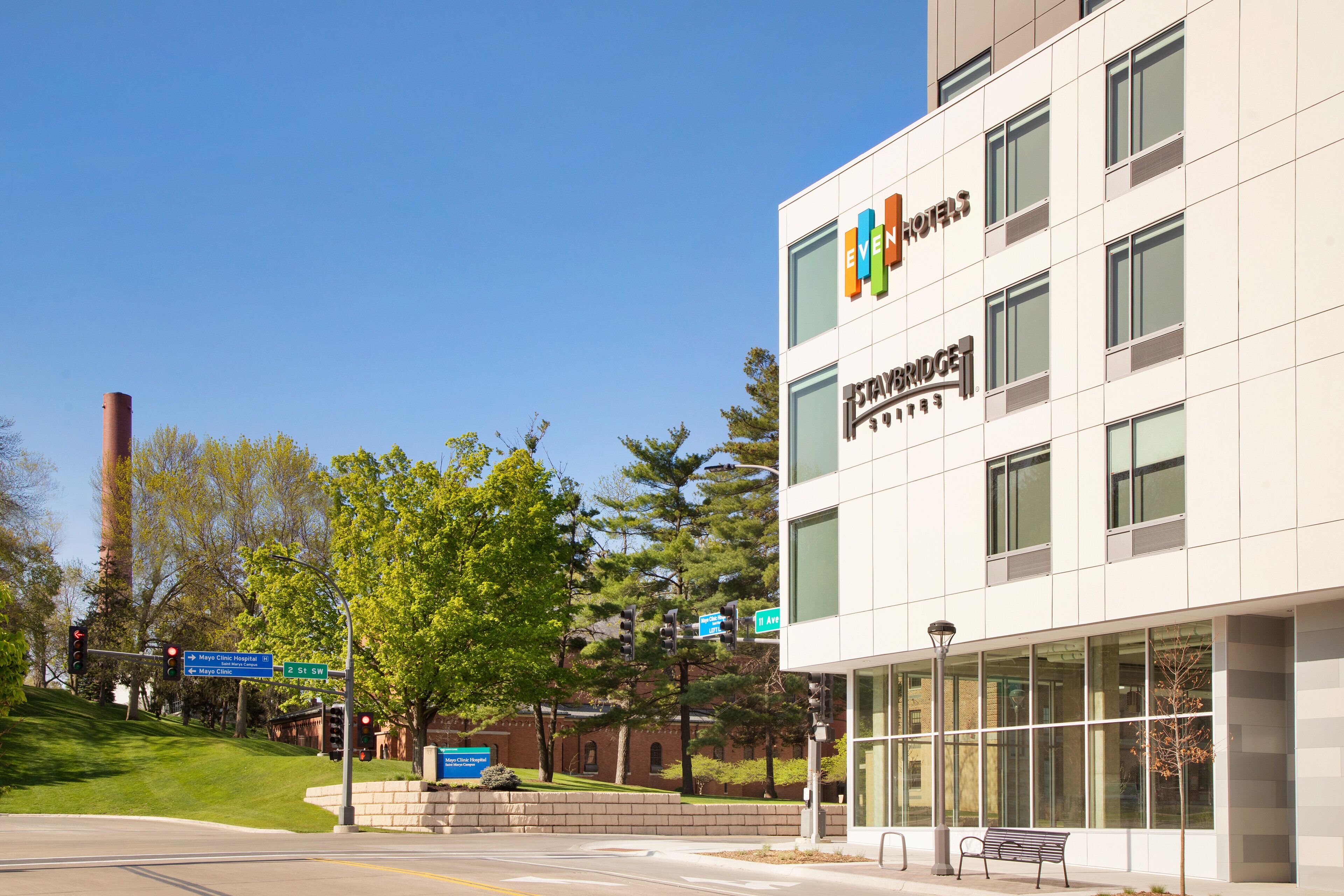 A modern hotel building with large windows and a sign for 'EVEN Hotels'.