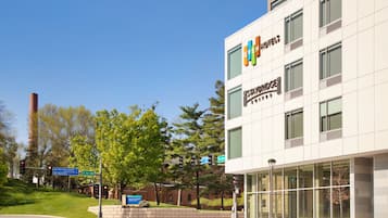 A modern hotel building with large windows and a sign for 'EVEN Hotels'.