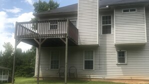 A two-story house with a covered porch and a chimney.