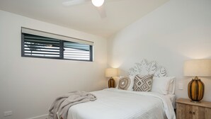 A bedroom with a bed, bedside lamps, a window with blinds, and a ceiling fan. - Designer Penthouse Overlooking Manly, the Ocean and Harbour (Manly)