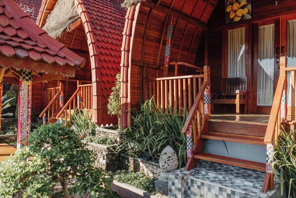 Una casa de madera tradicional con un porche, escalones y un piso de espinela.