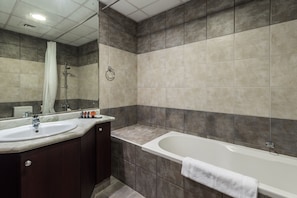 A modern bathroom with a large sink, a bathtub, and a mirror.