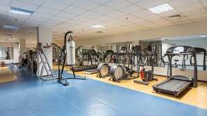 A gym with various exercise equipment, including treadmills, elliptical machines, and weight machines.