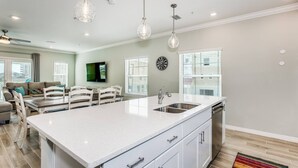 A spacious kitchen with a large island, white cabinetry, and pendant lighting. - Stunning Corner Townhome |Gulf Views |Beach Parking Pass |Dog Friendly |Free Golf |Beach Club |Pools (Pensacola)