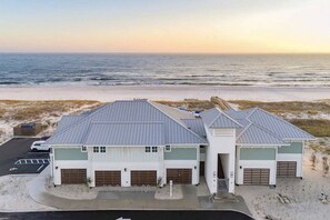 A coastal building with a flat roof, multiple garage doors, and a parking lot.
