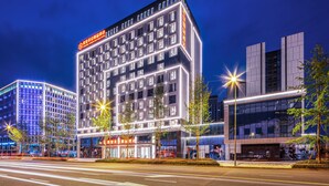 Ein modernes Hotel mit auffälliger Beschilderung, mehreren Etagen und einer gut beleuchteten Fassade.
