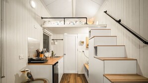 A compact kitchen with a wooden countertop, a built-in bench, and a small dining table.