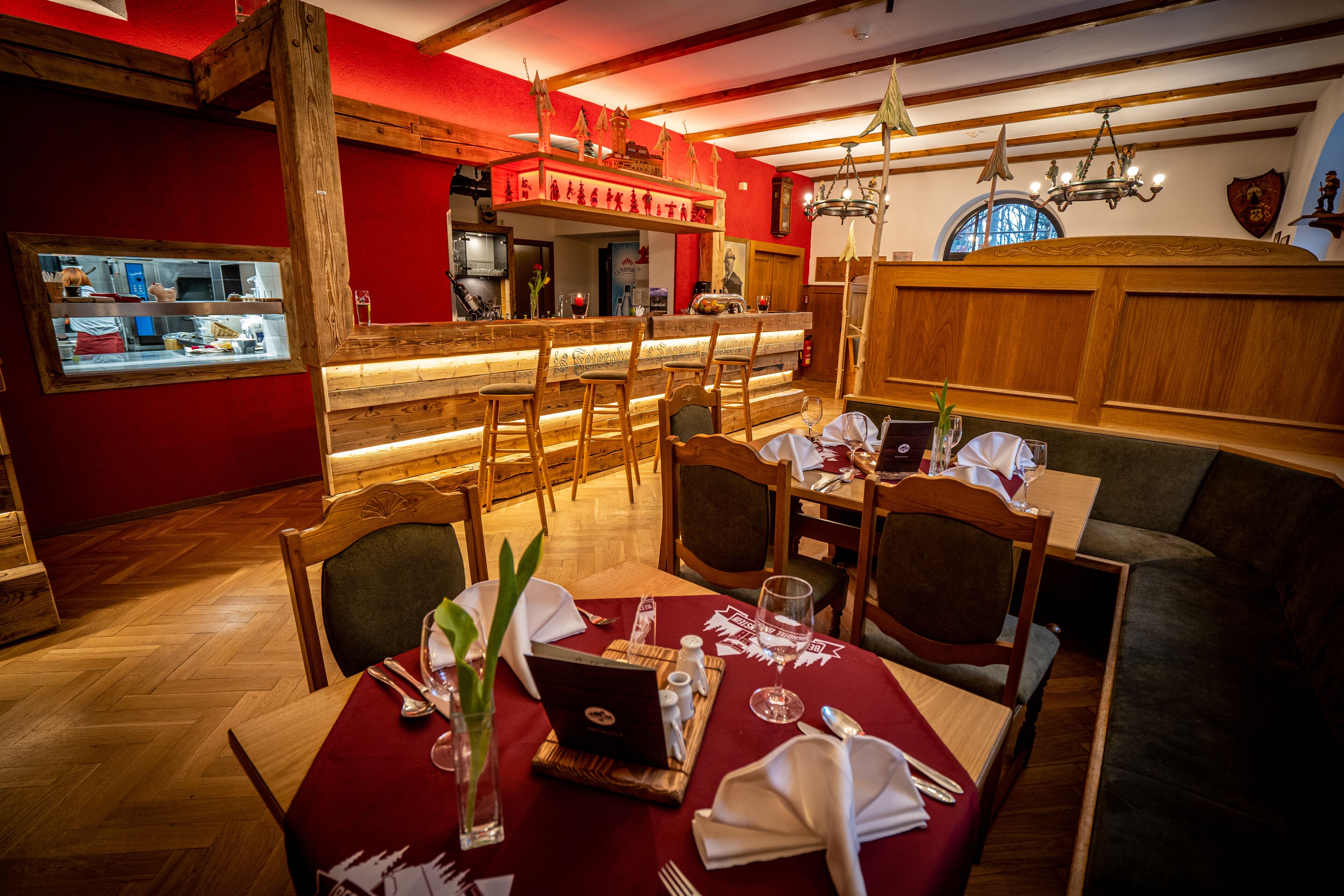 A restaurant with wooden furniture, a bar area, and a cozy ambiance.