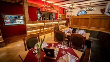Un restaurante con muebles de madera, una zona de bar y un ambiente acogedor.
