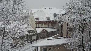 Un edificio innevato con diversi piani e un tetto spiovente.