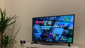 Ein Fernseher zeigt eine Netflix-Oberfläche mit verschiedenen Fernsehprogrammen und Filmen.