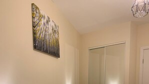 Ein Schlafzimmer mit Bett, Nachttischlampe und einem Bild an der Wand.