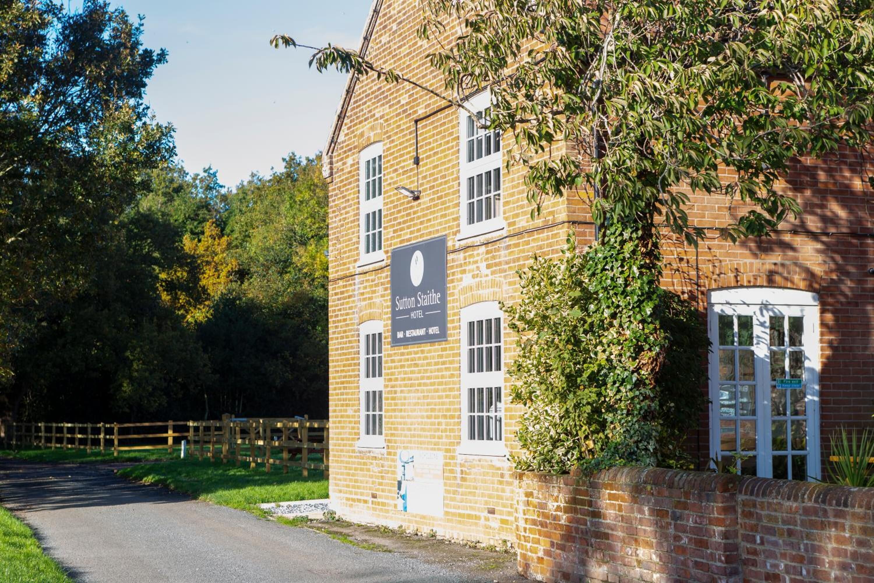 A brick building with a sign reading "Sutton Stanhope Hotel."