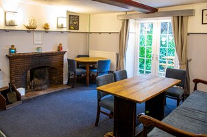 A cozy room with a fireplace, a round table, and blue chairs.