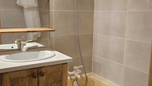 Ein Badezimmer mit einem Holz-Waschtisch, einem weißen Waschbecken und einer Badewanne.