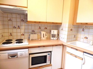 Eine Küche mit Herd, Mikrowelle, Toaster und Kaffeemaschine.