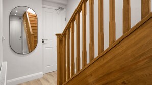 A staircase with wooden railings and a white door with a mirror. - 2 Bedroom Apartment near Town Center (Reading)