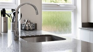 A kitchen with a stainless steel sink, a utensil holder, and a window with a view of greenery. - 2 Bedroom Apartment near Town Center (Reading)