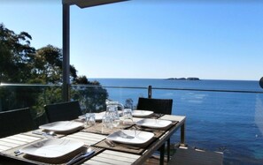 Enjoy a meal with a view of the sea and distant islands from this outdoor dining area.