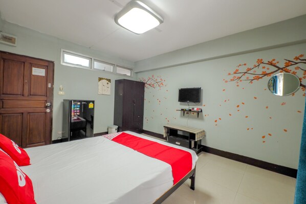 A hotel room with a bed, a wardrobe, a desk, a television, and a vending machine. - OYO 75362 Swagath Home (Bangkok)