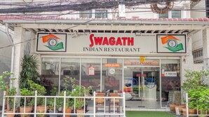 An Indian restaurant named Swagath with a signboard, potted plants, and a welcome sign. - OYO 75362 Swagath Home (Bangkok)