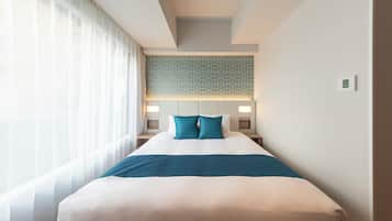A hotel room with a large bed, a headboard with a geometric pattern, and a bedside table with a lamp.