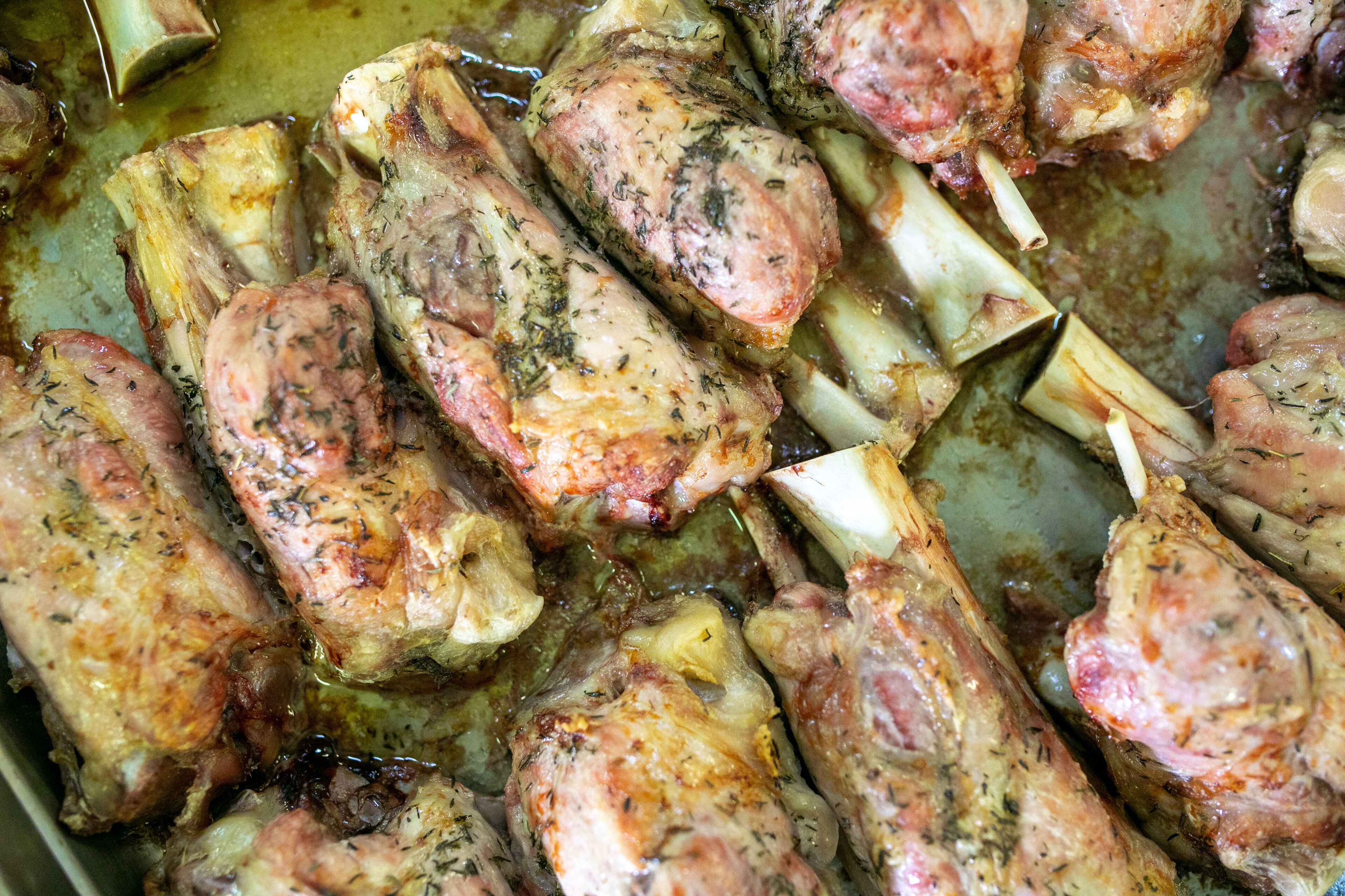 A close-up of cooked chicken pieces with herbs.