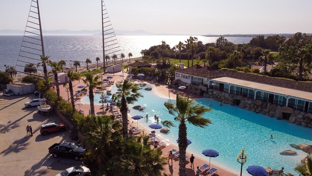 Un resort con piscina, zona de playa y vista al mar.