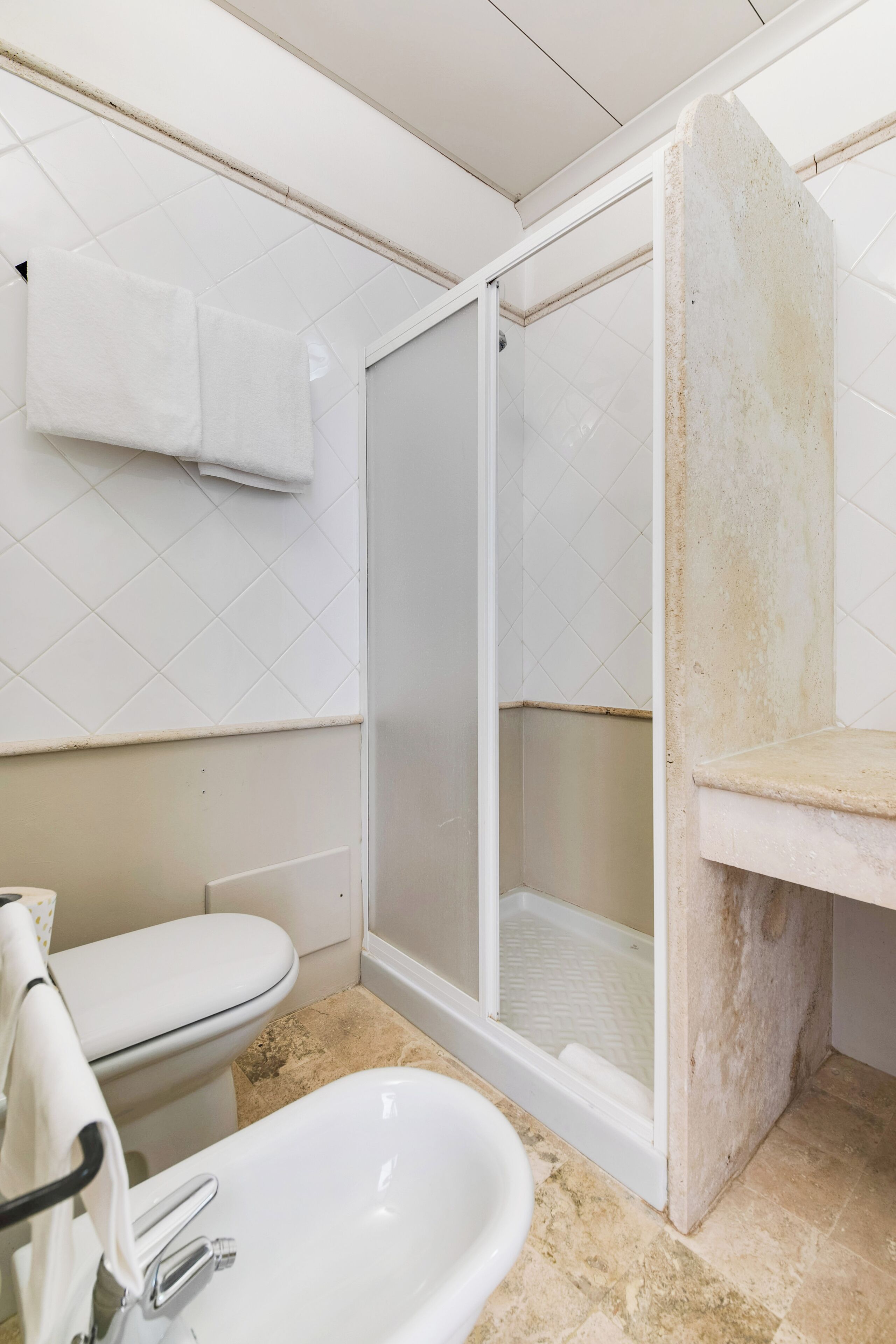 Un baño con inodoro, lavabo y zona de ducha.
