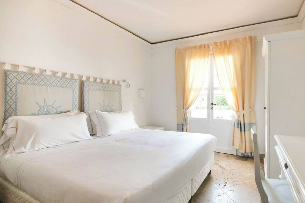 Ein Schlafzimmer mit Bett, Vorhängen und einer Tür.