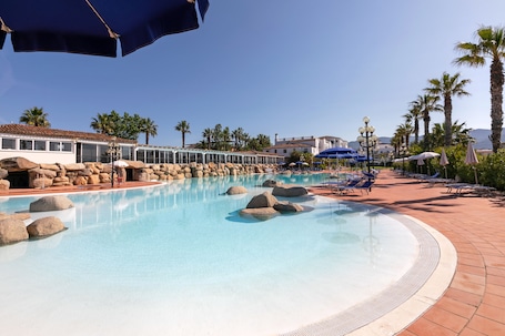 Una piscina al aire libre de temporada, sombrillas
