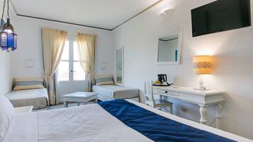 Una habitación de hotel con dos camas, un escritorio, una silla, un televisor y una lámpara.
