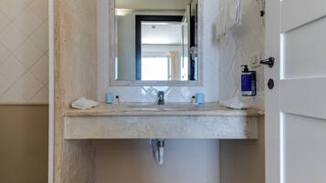 Een badkamer met een wastafel, spiegel en toiletartikelen.