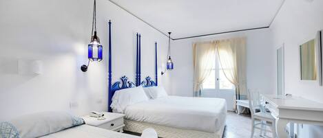 Hotellihuone, jossa on kaksi sänkyä, työpöytä ja tuoli.