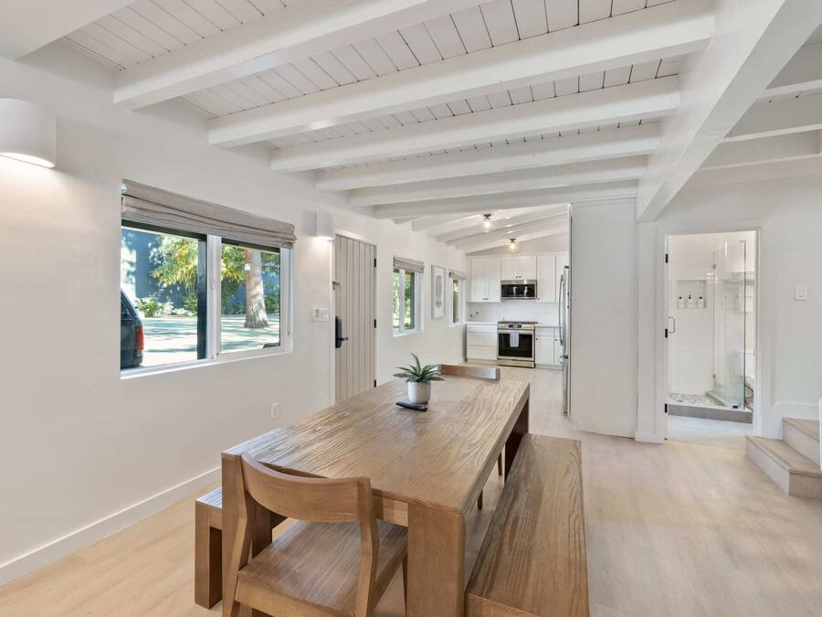 A spacious kitchen with modern appliances and a large dining area with wooden furniture.
