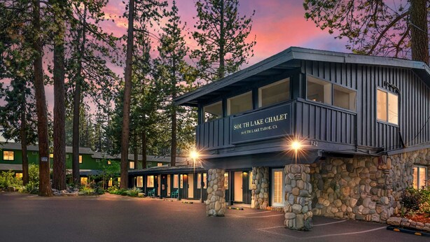 Una cabaña con base de piedra y estructura superior de madera, llamada 'South Lake Chalet' en South Lake Tahoe, California.