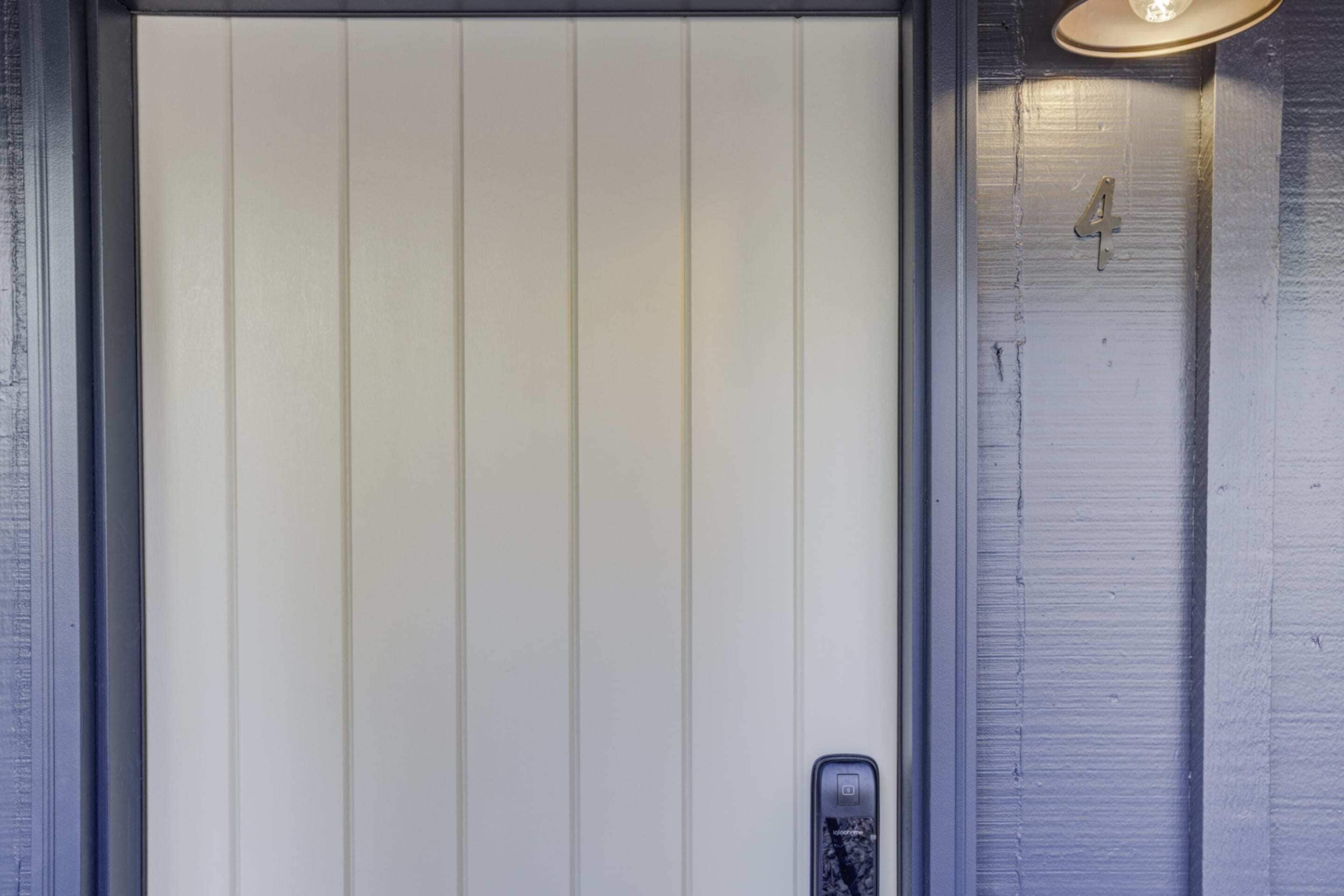 A white door with vertical paneling and a small, rectangular handle.