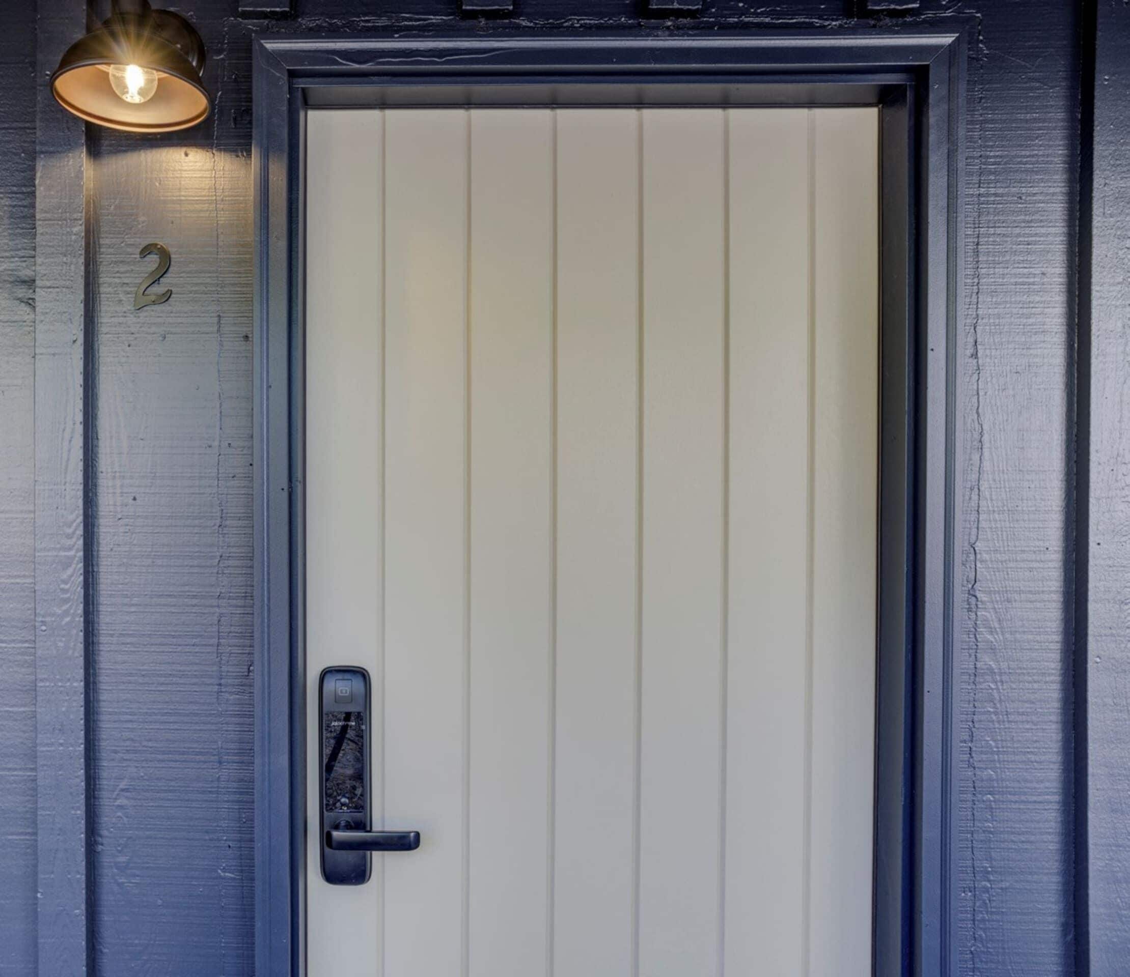 Une porte avec le numéro « 2 » sur le mur, une poignée de porte et un luminaire au-dessus.