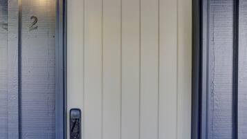 Une porte avec le numéro « 2 » sur le mur, une poignée de porte et un luminaire au-dessus.