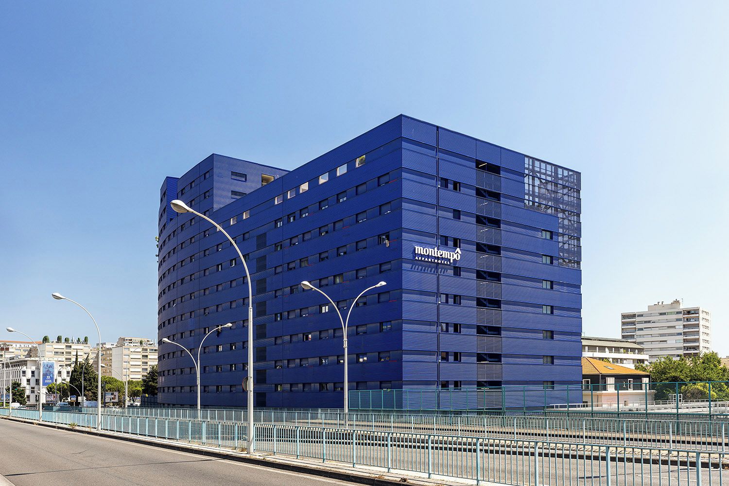 A modern multi-story building with a prominent 'montempo' sign, featuring a grid-like facade and multiple windows.