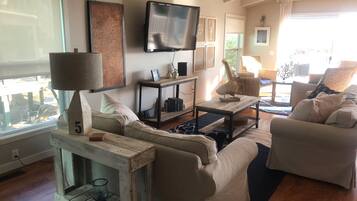 A living room with two sofas, a coffee table, a TV, and a bookshelf.