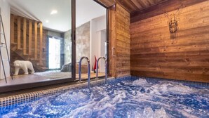 A hot tub with a view of a wooden interior and a polar bear statue. - Chalet with spa/heated pool, lake view, ski-in/ski-out access, fire pit, 5-star rating (Les Angles)