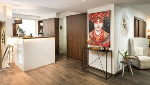 Une cuisine moderne dotée d’un îlot central, de meubles en bois et d’un élément décoratif mural.