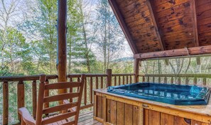 Eine Holzterrasse mit Whirlpool, Holzgeländer und einem Stuhl.