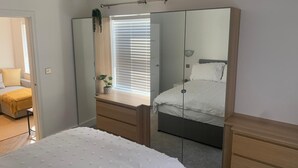 A bedroom with a bed, a wardrobe, a bedside table, and a window with blinds. - Unique 1 bedroom in Reading (Reading)