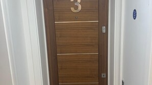 A wooden door with the number 3, white walls, and a doormat at the entrance. - Unique 1 bedroom in Reading (Reading)