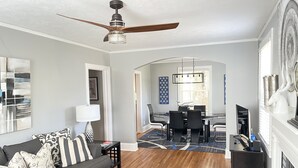 A modern living room with a sofa, coffee table, and a dining area with a table and chairs.