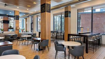 Ein modernes Café mit Holzsäulen, runden Tischen und Stühlen.